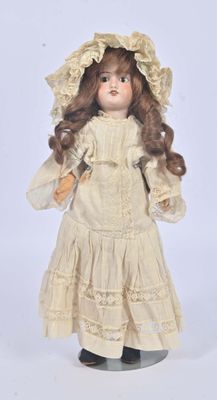 an antique doll of a woman in a white dress and bonnet