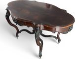 une table basse ovale en acajou, avec des pieds sculptés et un plateau incurvé