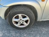 a silver car with a flat tire on the street