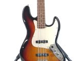 an electric bass guitar sitting on top of a stand on a white surface
