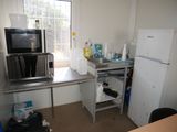 a small kitchen with a refrigerator, microwave, and a table