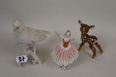 three figurines of animals and a bird on a white surface