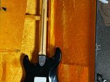 a black electric guitar in a case on the floor