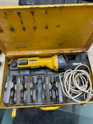 une boîte à outils jaune contenant des outils, posée sur une table