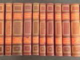 six vieux livres sont empilés sur une table