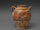 un vieux vase marron orné de motifs sur un fond gris