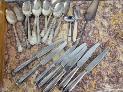beaucoup de cuillères et de couteaux-cuillères en argent sur le comptoir