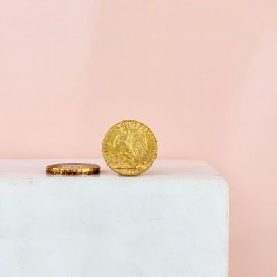 a gold coin sitting on top of a white box