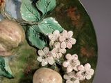 a plate with fruit and flowers on it on a table