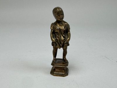 figurine en bronze représentant un garçon coiffé d'un chapeau, posée sur un socle