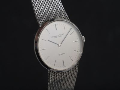 une image montrant un gros plan d'une montre argentée sur fond noir