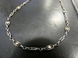a close up of a necklace on a table with a chain