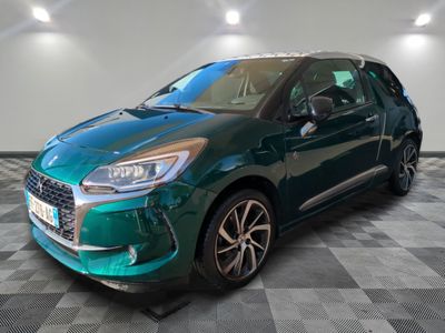 a green citrole parked on a checkered floor in a garage