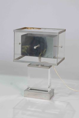 une horloge placée dans une vitrine posée sur un socle