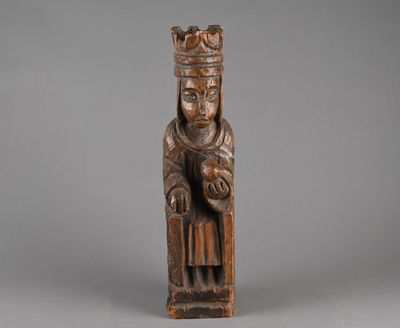 an old wooden statue of a man with a crown on his head