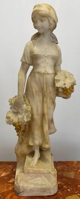 statue of a woman holding a basket of flowers on a wooden table