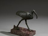 statue en bronze représentant un oiseau posée sur un socle en pierre
