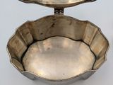 two silver dishes are sitting on a white surface