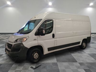 la camionnette blanche est garée sur un sol carrelé en damier