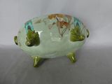 a green bowl with a turtle on it on a stand