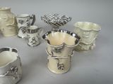 a lot of cups and mugs that are sitting on a table