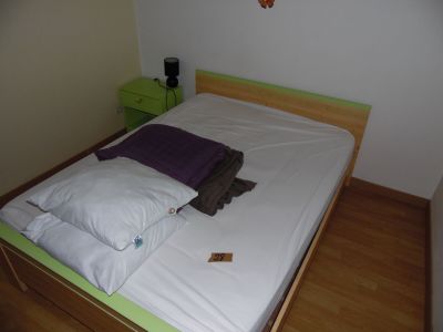 a bed with a white sheet on it in a small room