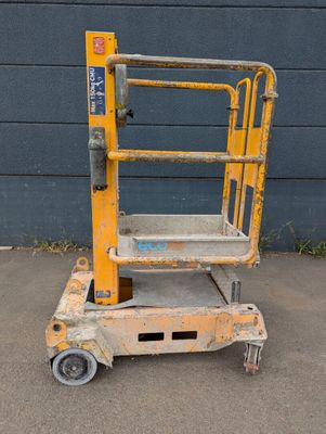 a close up of a yellow scissor sitting on top of a parking lot