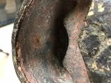 a close up view of a rusted vase with a hole in it
