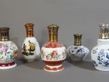 Plusieurs vases aux motifs variés sont alignés sur une surface grise