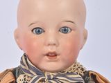 an image of a doll with blue eyes and a bow tie