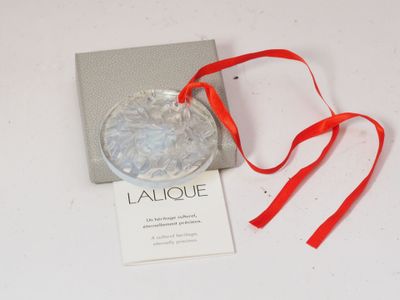 une photo d'une décoration en verre ornée d'un ruban rouge