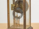 a small clock that is sitting on a wooden table