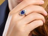 an image of a woman wearing a blue sapphire and diamond ring