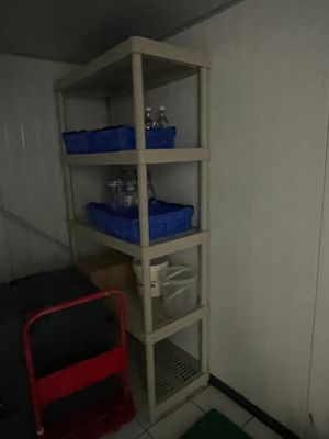 une pièce dans laquelle se trouvent une étagère et une chaise rouge