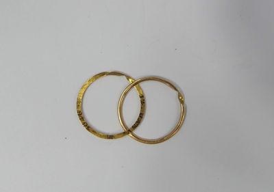 two gold wedding rings on a white surface