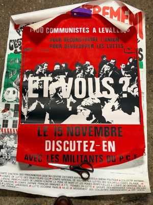 a poster on the ground with a pair of scissors next to it