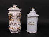 pair of white and gold decorated jars with black writing on them