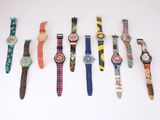 de nombreuses montres alignées sur une surface blanche