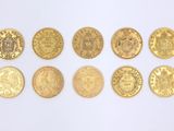 several gold coins are arranged in a row on a white surface