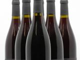 six bouteilles de vin sont alignées sur une surface blanche