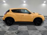 a yellow nissan juke suv parked in a garage