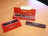 two pens and a pen case on a wooden table