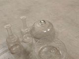 several glass vases and a bowl on the floor