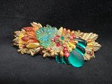 an image of a brooch with flowers and leaves on it