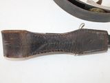 a knife that is laying on a table next to a belt