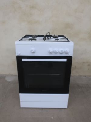 a white stove with a black burner and a white oven top