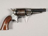 an old revolver with a wooden handle on a white surface