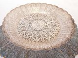 a silver plate with a design on it on a table