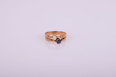 gros plan d'une bague en or avec une pierre bleue