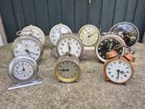 a lot of clocks sitting on a table next to each other
